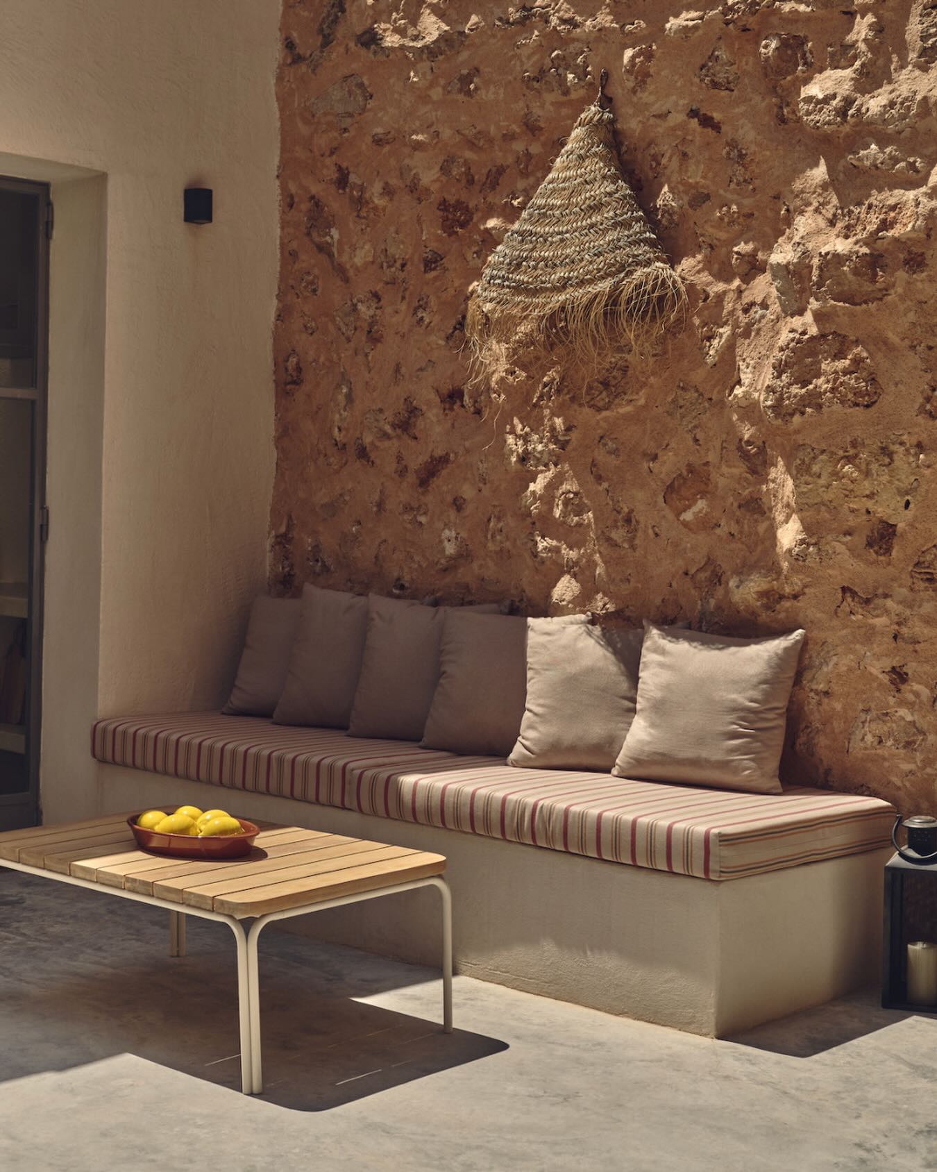 El banco marca el límite. Los cojines cambian la experiencia. Aportan apoyo, suavizan la piedra y hacen que sentarse sea algo natural.El textil no compite con el entorno. Lo acompaña. Hace que el espacio se use, no solo que se mire.Ese es el confort que funciona.